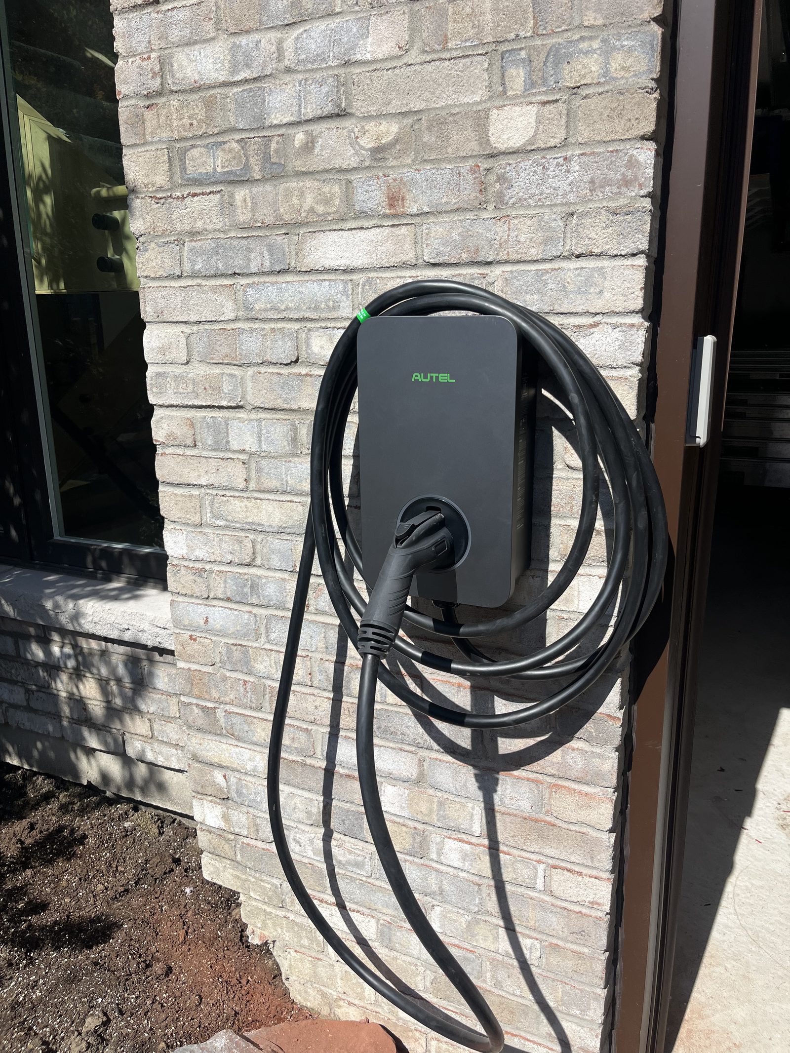 Autel MaxiCharger EV charger installed on exterior brick wall, GTA home